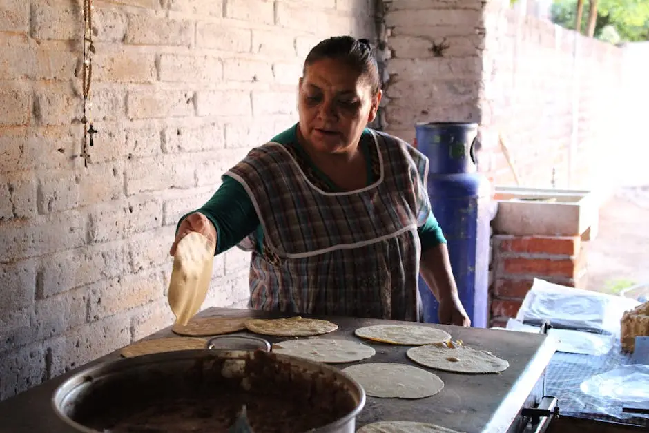 A woman prepares tortillas in a rustic setting in Usmajac, showcasing traditional Mexican cooking methods.